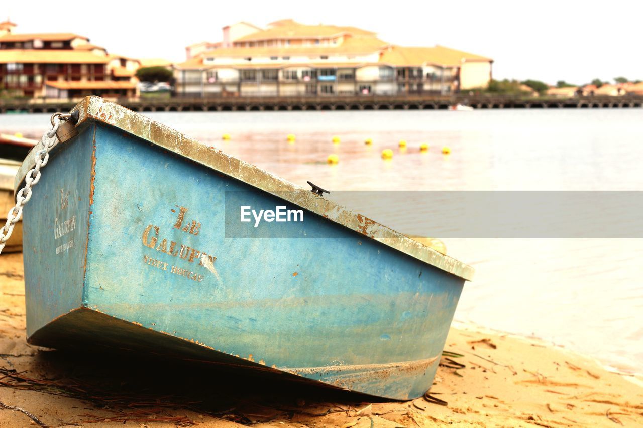 BOAT MOORED IN WATER AGAINST SKY