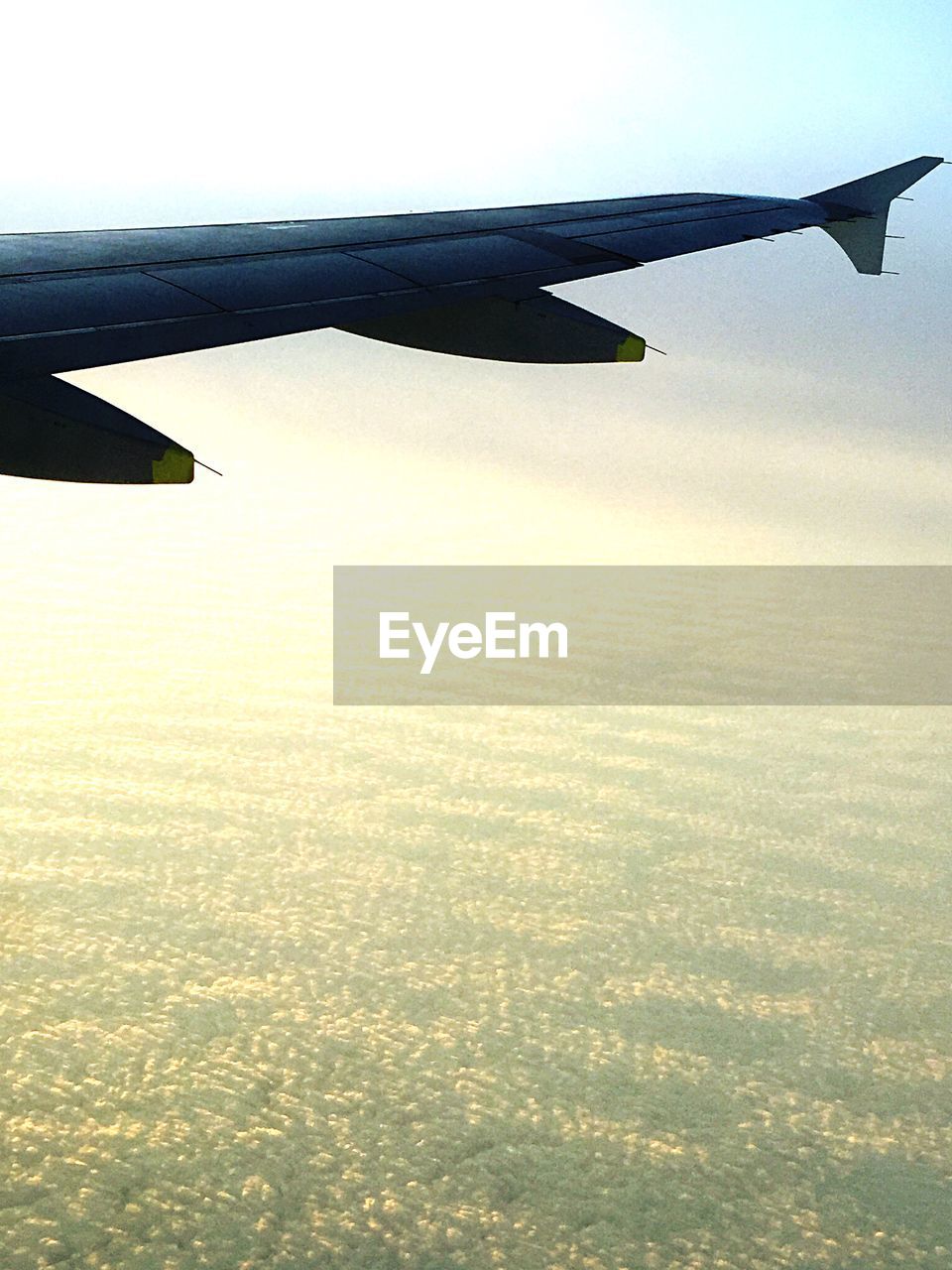 Cropped image of airplane flying over clouds