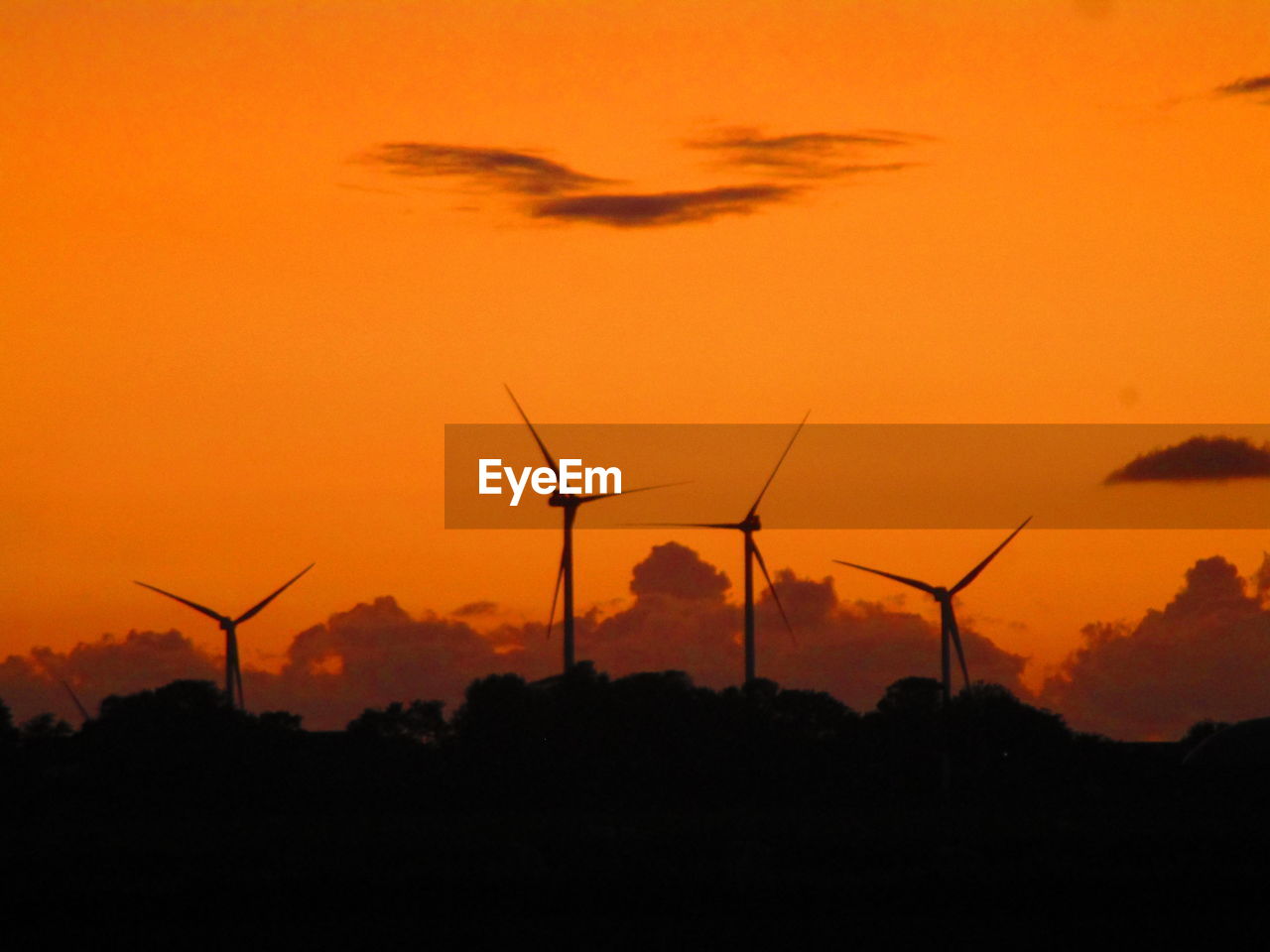 SILHOUETTE WIND TURBINES ON FIELD AGAINST SKY DURING SUNSET