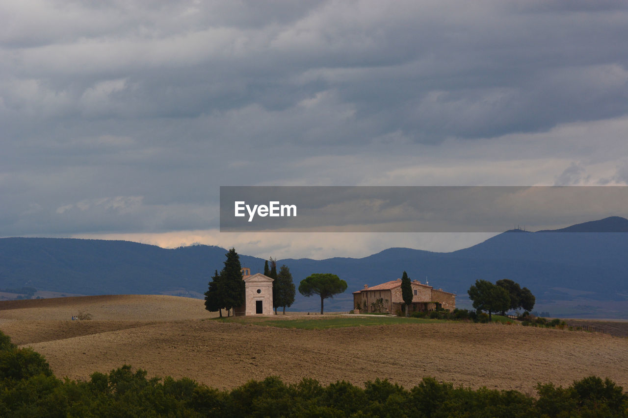 cloud, hill, architecture, sky, landscape, built structure, building, environment, land, building exterior, nature, scenics - nature, horizon, house, rural area, travel destinations, no people, beauty in nature, history, the past, plant, travel, rural scene, religion, tourism, plain, plateau, outdoors, mountain range, tranquility, field, place of worship, natural environment, non-urban scene, day, tranquil scene, tree, water