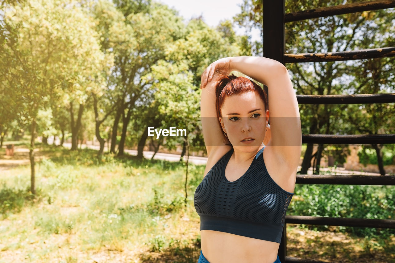 Woman doing stretching exercise in garden