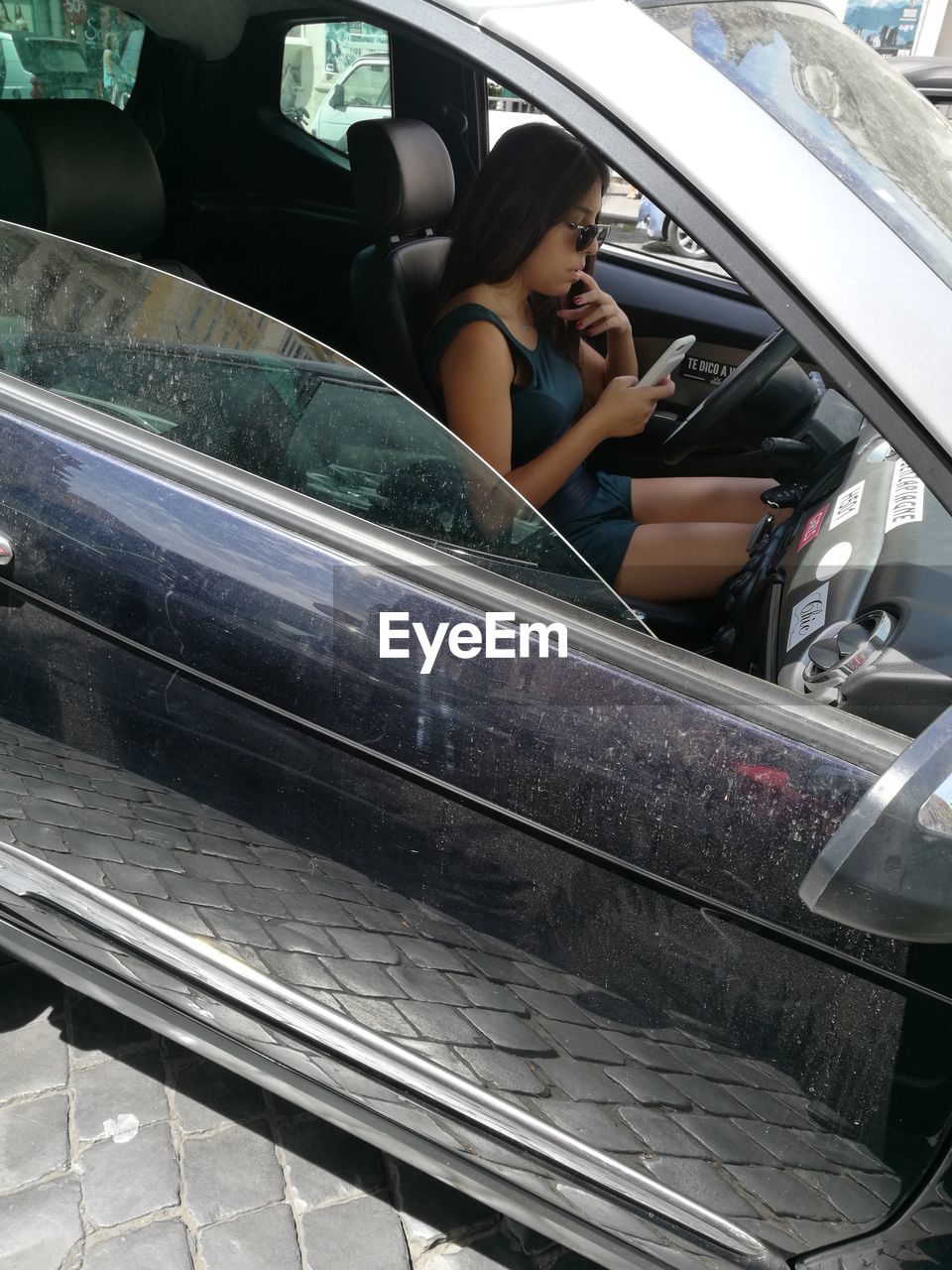 WOMAN SITTING ON CAR
