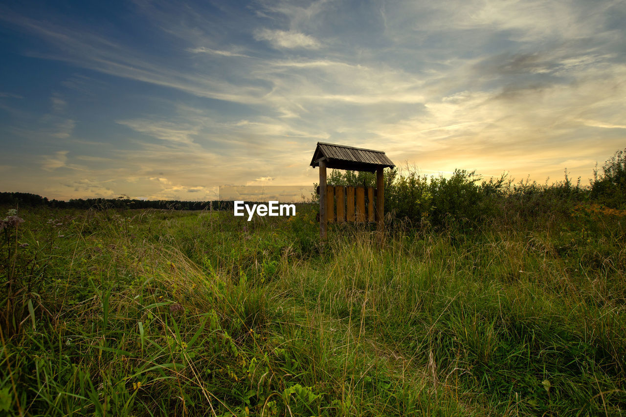 Built structure on field against sky during sunset