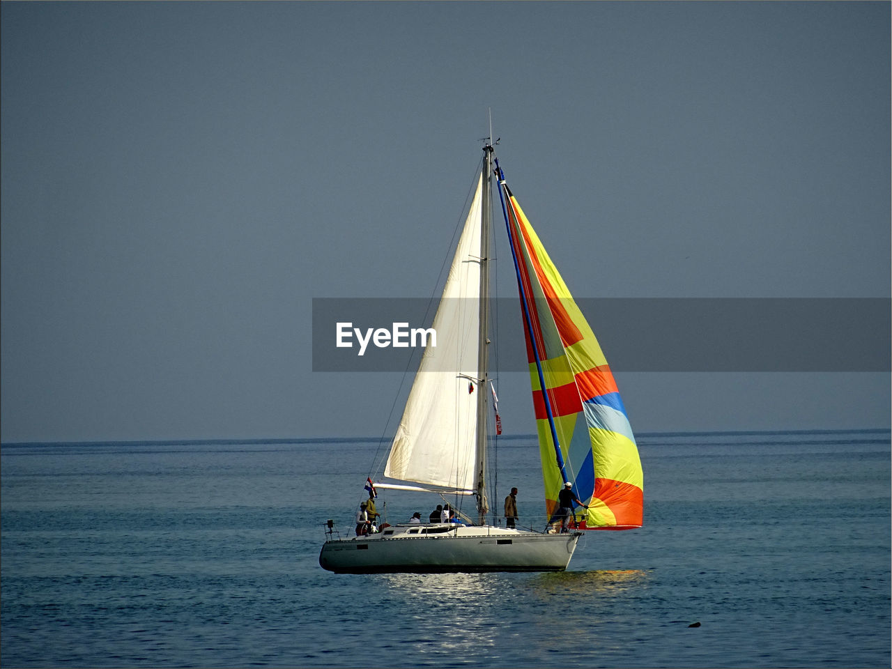 People in boat on sea against clear sky