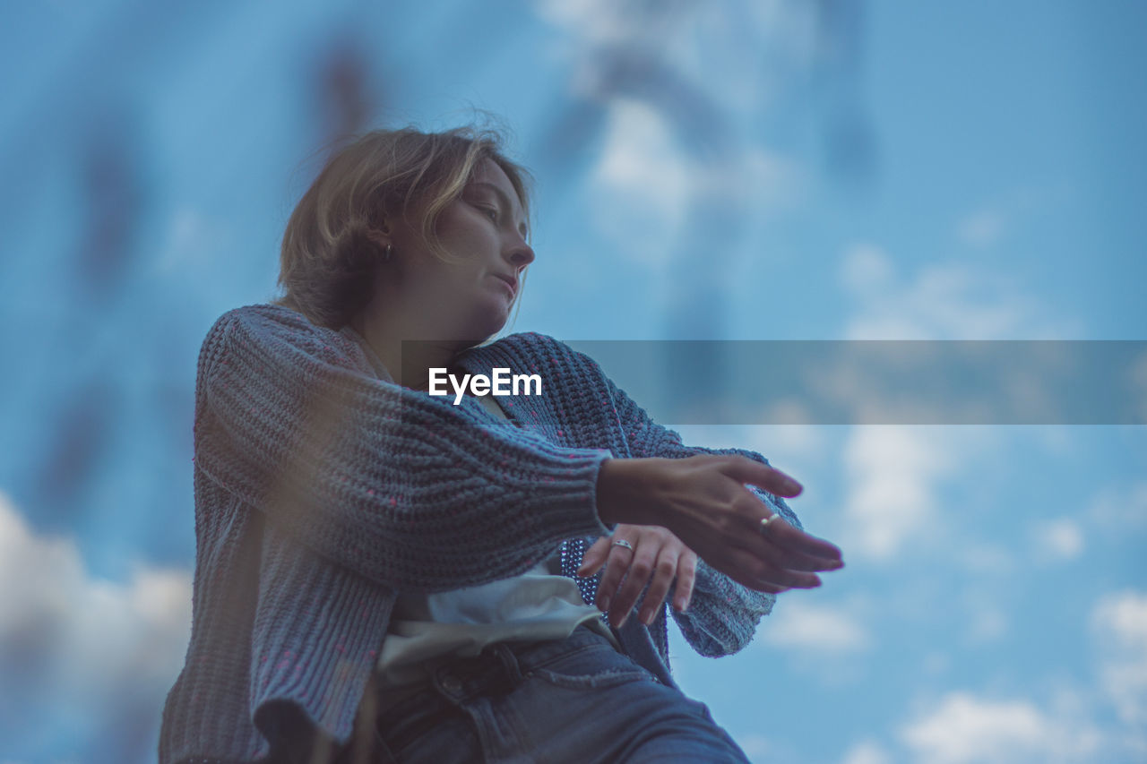 Low angle view of woman dancing against sky