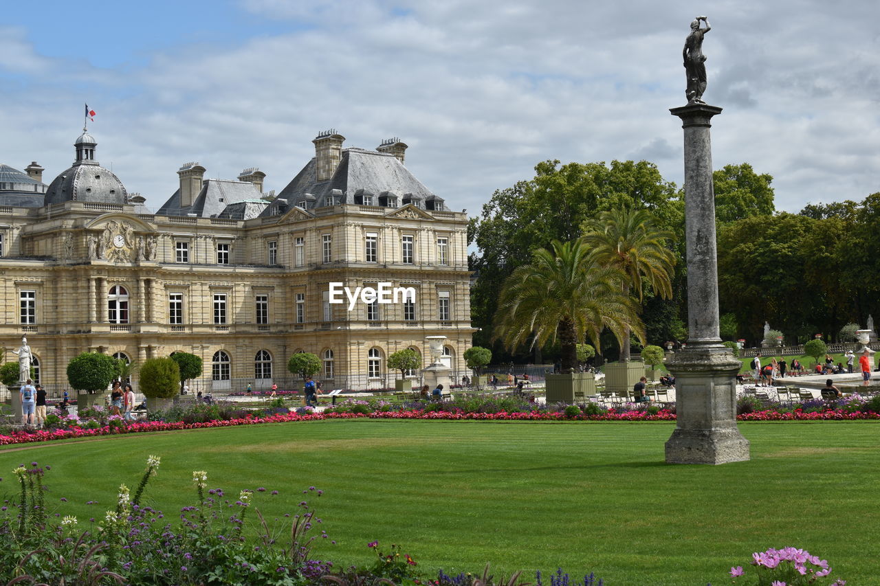 STATUE IN GARDEN AGAINST BUILDINGS