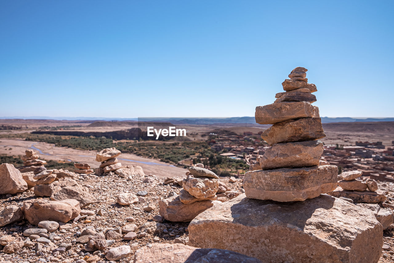Stack of stones or rocks on mountain landscape against sky