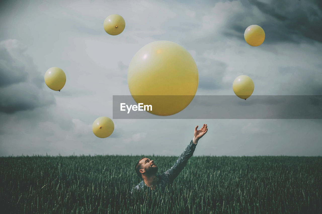 MAN STANDING ON FIELD AGAINST SKY