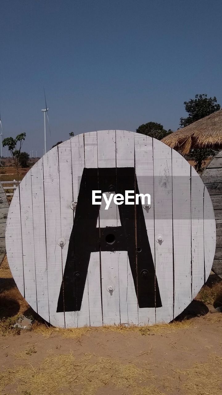 Information sign on field against clear sky