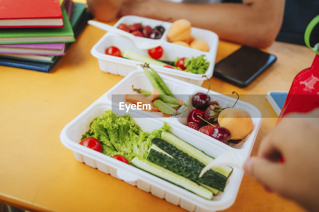 Fresh fruit and vegetable in lunch box on table