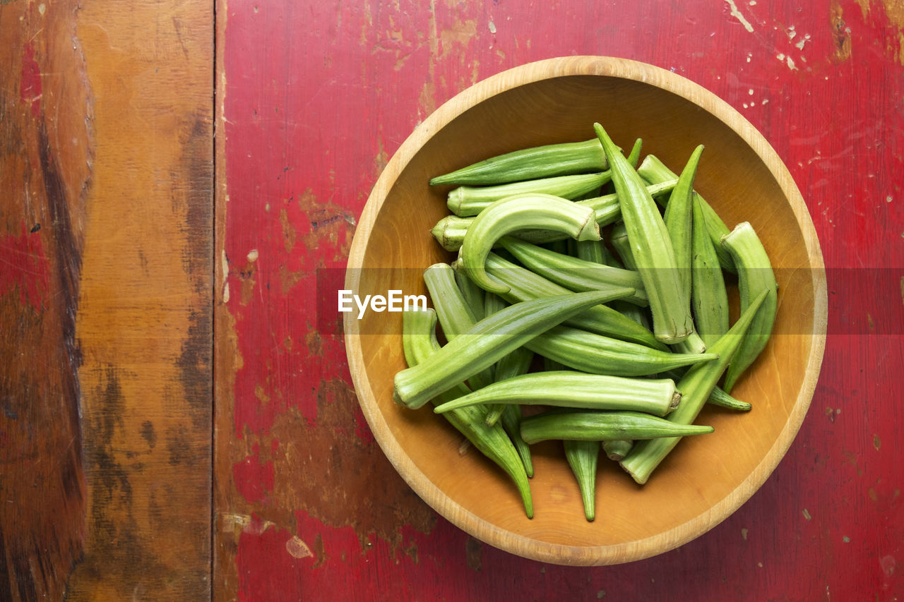 Okra in a bowl on a red table