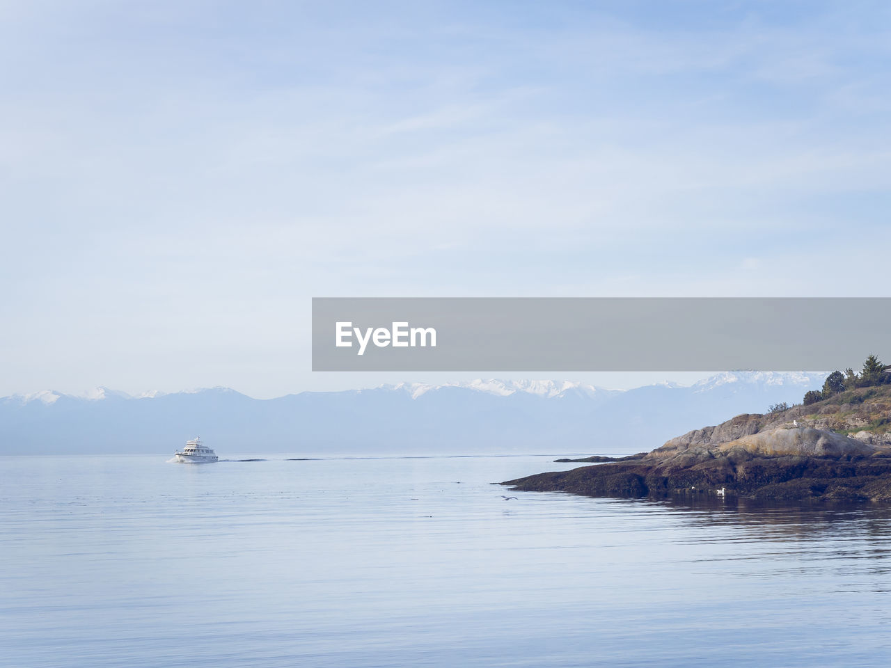 Scenic view of sea and mountains against sky