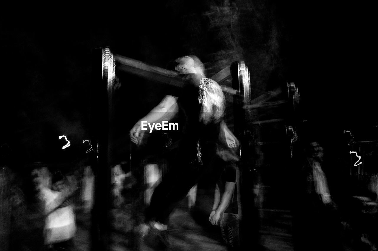 GROUP OF PEOPLE DANCING IN DARK ROOM