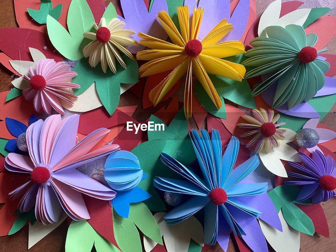 wheel, multi colored, flower, art, origami paper, petal, no people, large group of objects, pinwheel toy, close-up, creativity, paper, pattern, high angle view, variation, craft, origami, art paper, abundance, blue