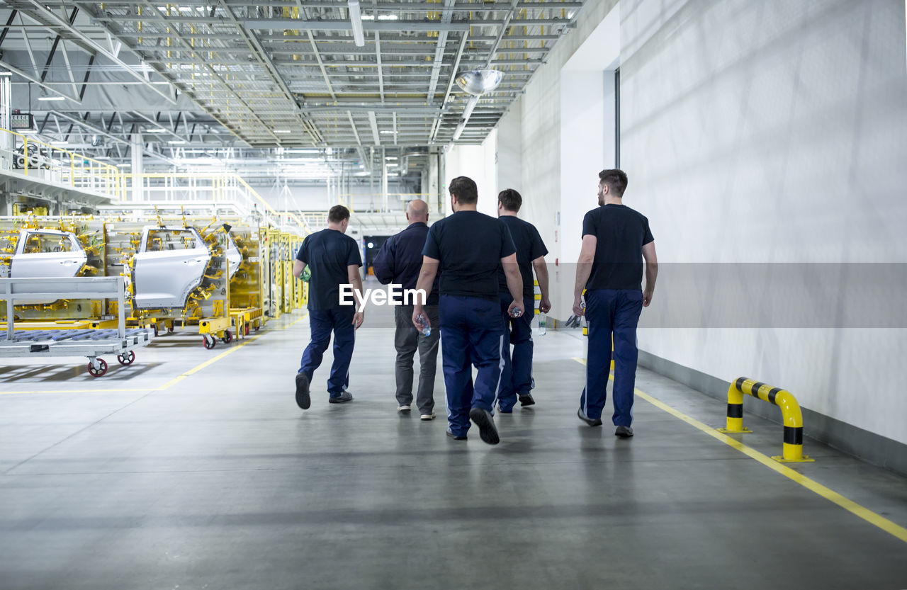 Colleagues having a break and walking in a modern car factory