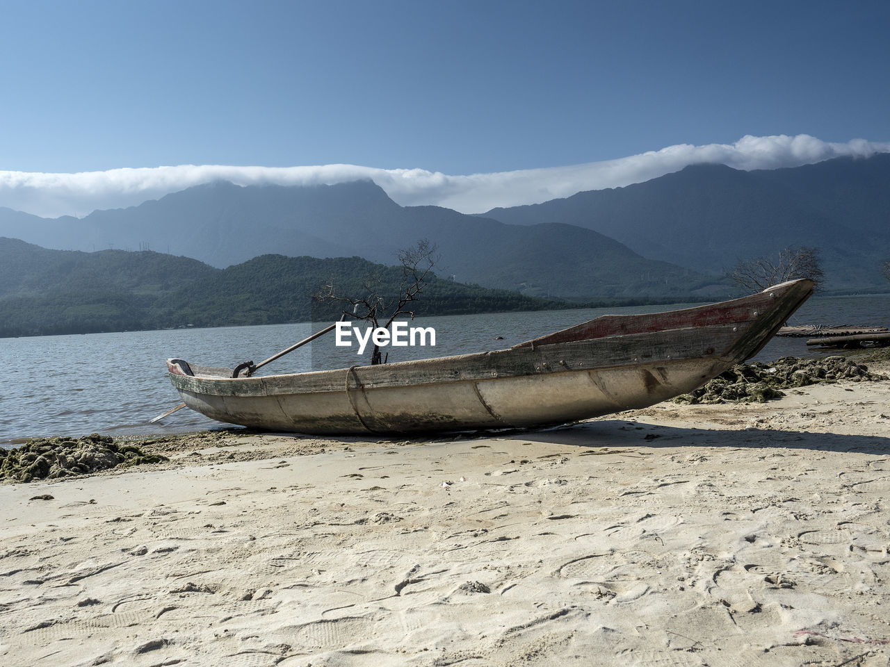 FISHING BOATS ON BEACH AGAINST MOUNTAINS