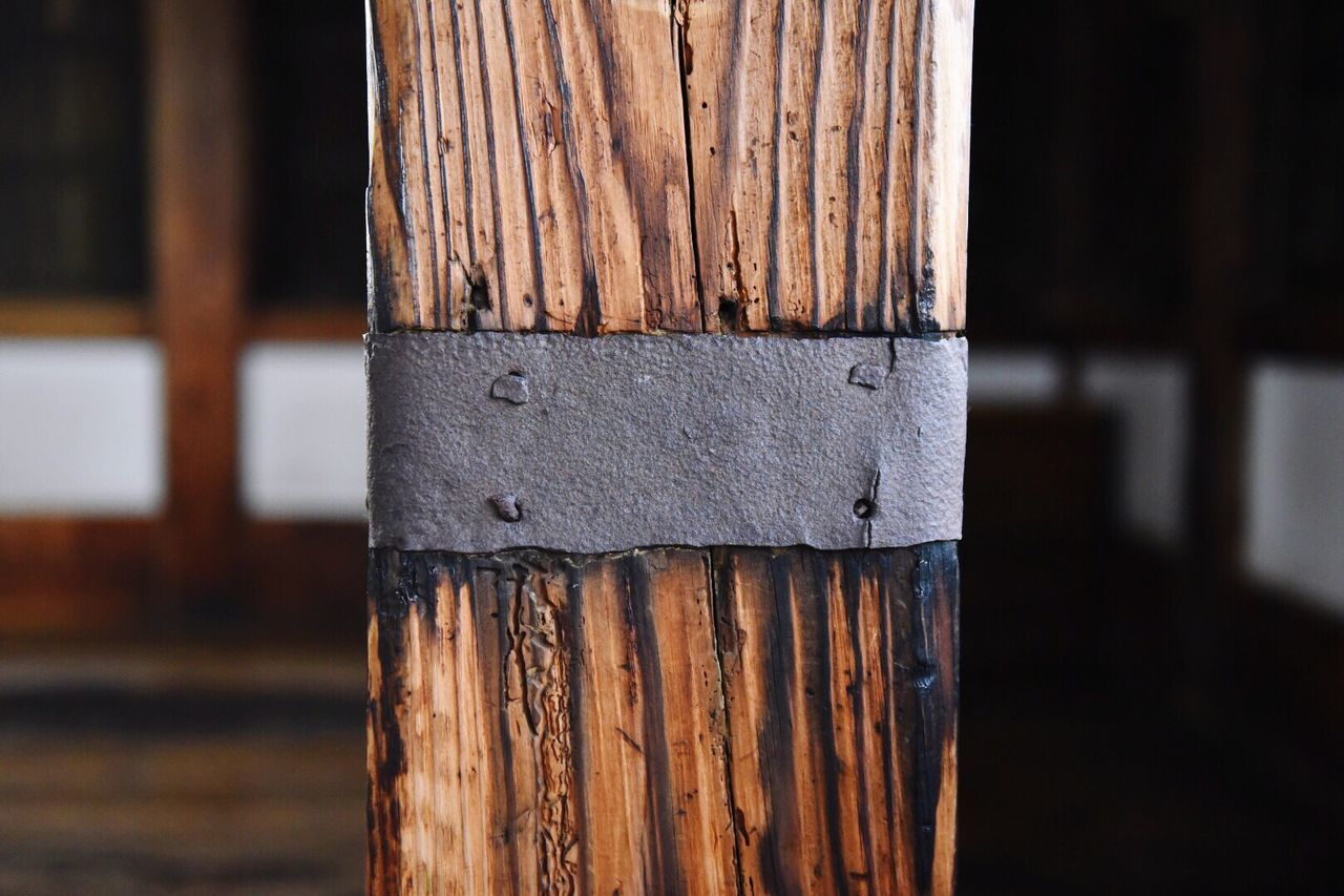 Close-up of metal mounted on wooden post