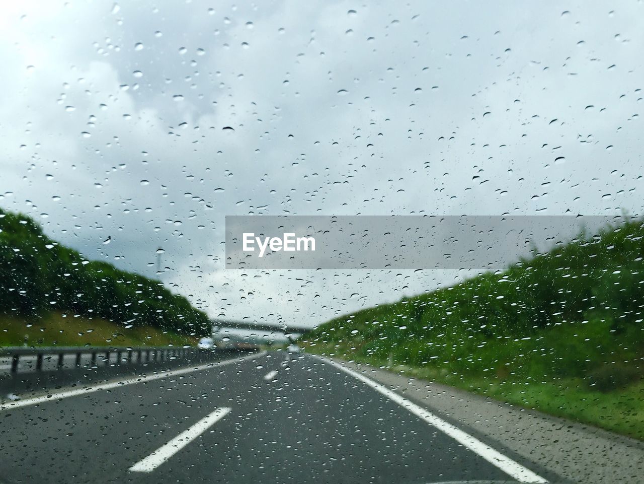 Empty road seen through wet windshield