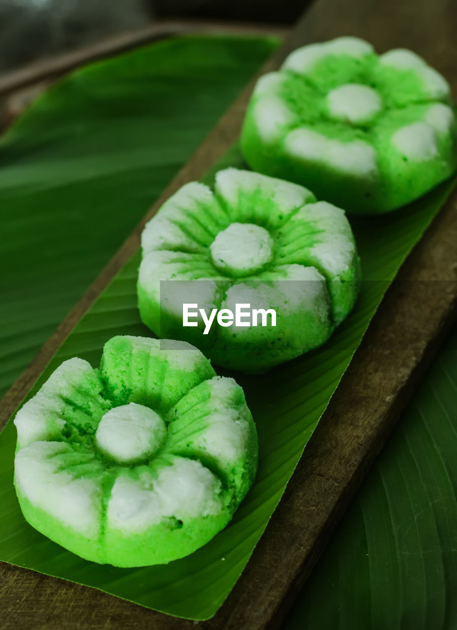 HIGH ANGLE VIEW OF GREEN FRUITS ON CUTTING BOARD