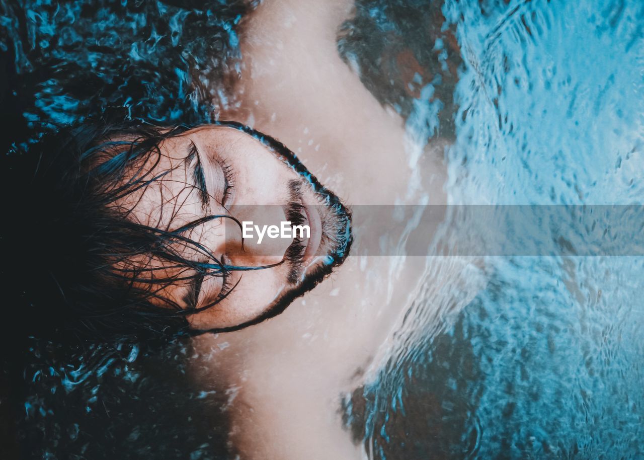 CLOSE-UP PORTRAIT OF YOUNG WOMAN WITH SWIMMING POOL