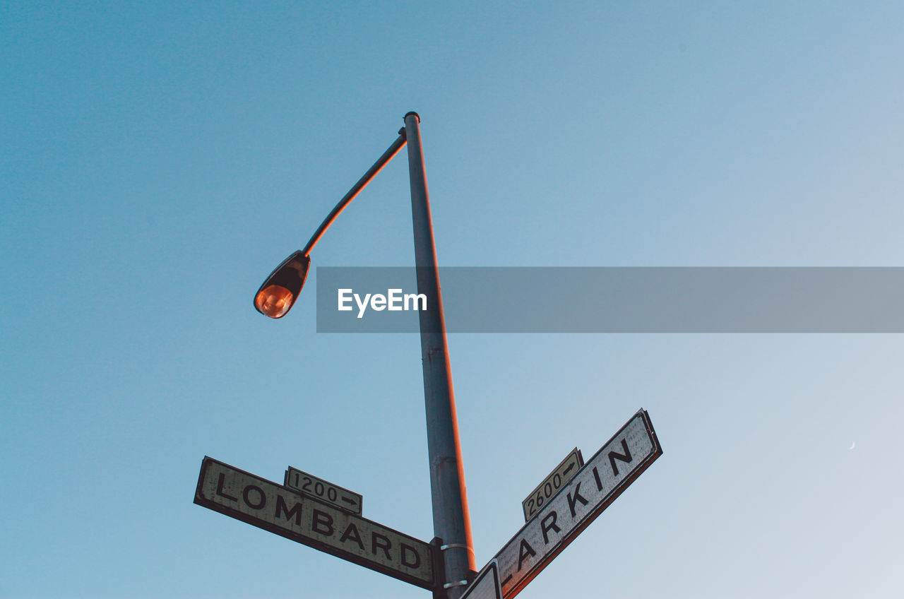 Low angle view of road sign against clear sky