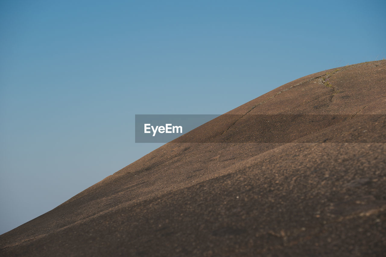 A large granite hill against the backdrop of a clear sky. no vegetation. natural background.