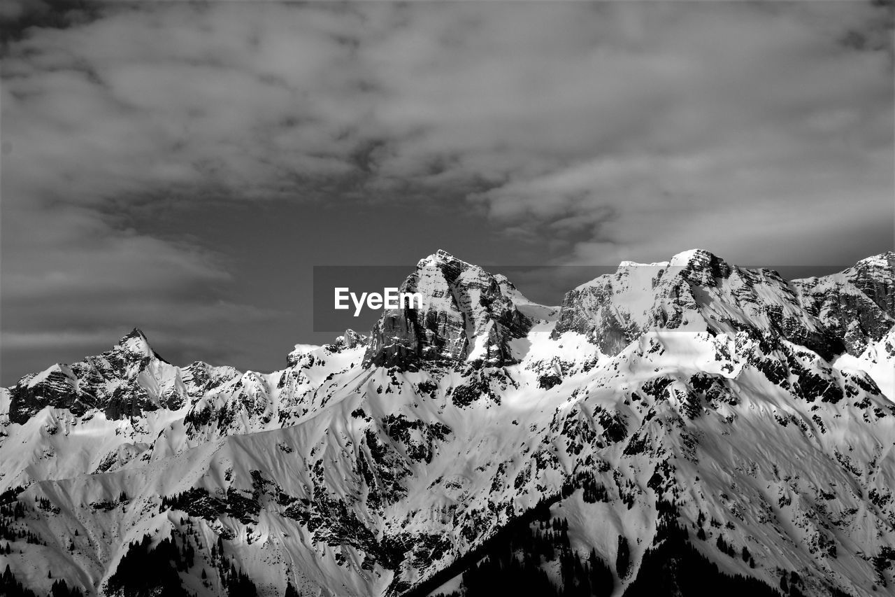 mountain, snow, cold temperature, winter, scenics - nature, sky, cloud, environment, beauty in nature, black and white, snowcapped mountain, landscape, mountain range, nature, monochrome, monochrome photography, tranquility, mountain peak, no people, extreme terrain, travel destinations, tranquil scene, white, outdoors, rock, non-urban scene, travel, day, land