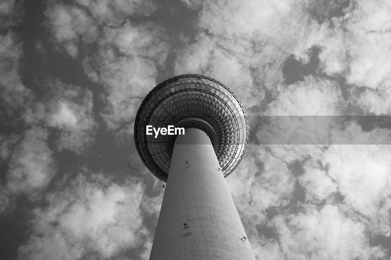 Low angle view of fernsehturm tower against cloudy sky