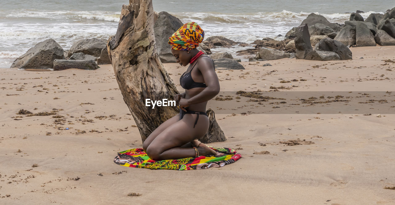 Side view of woman wearing bikini bottom at beach