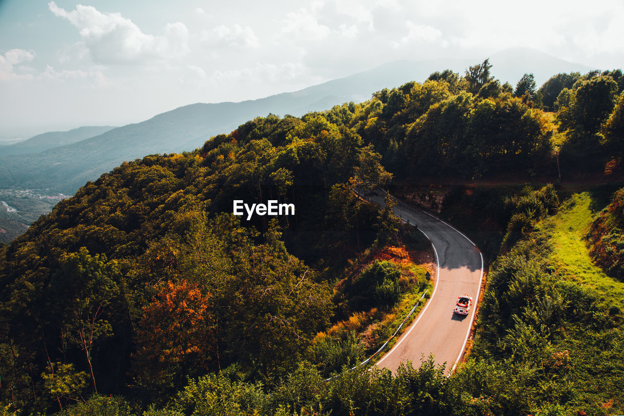 high angle view of road amidst trees against sky