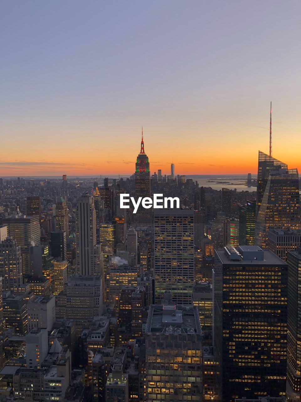 Aerial view of city lit up at sunset