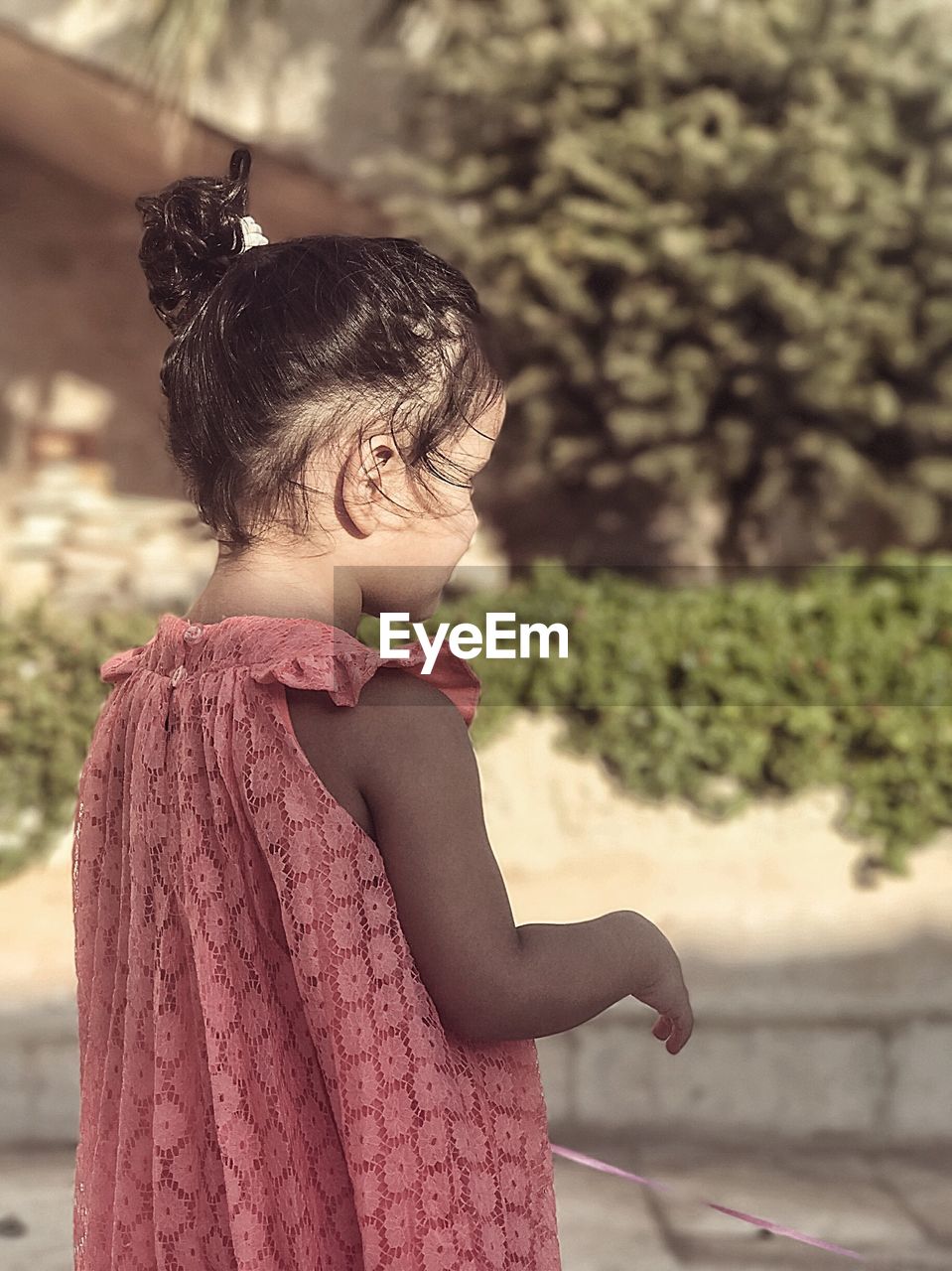 Side view of girl standing against plants