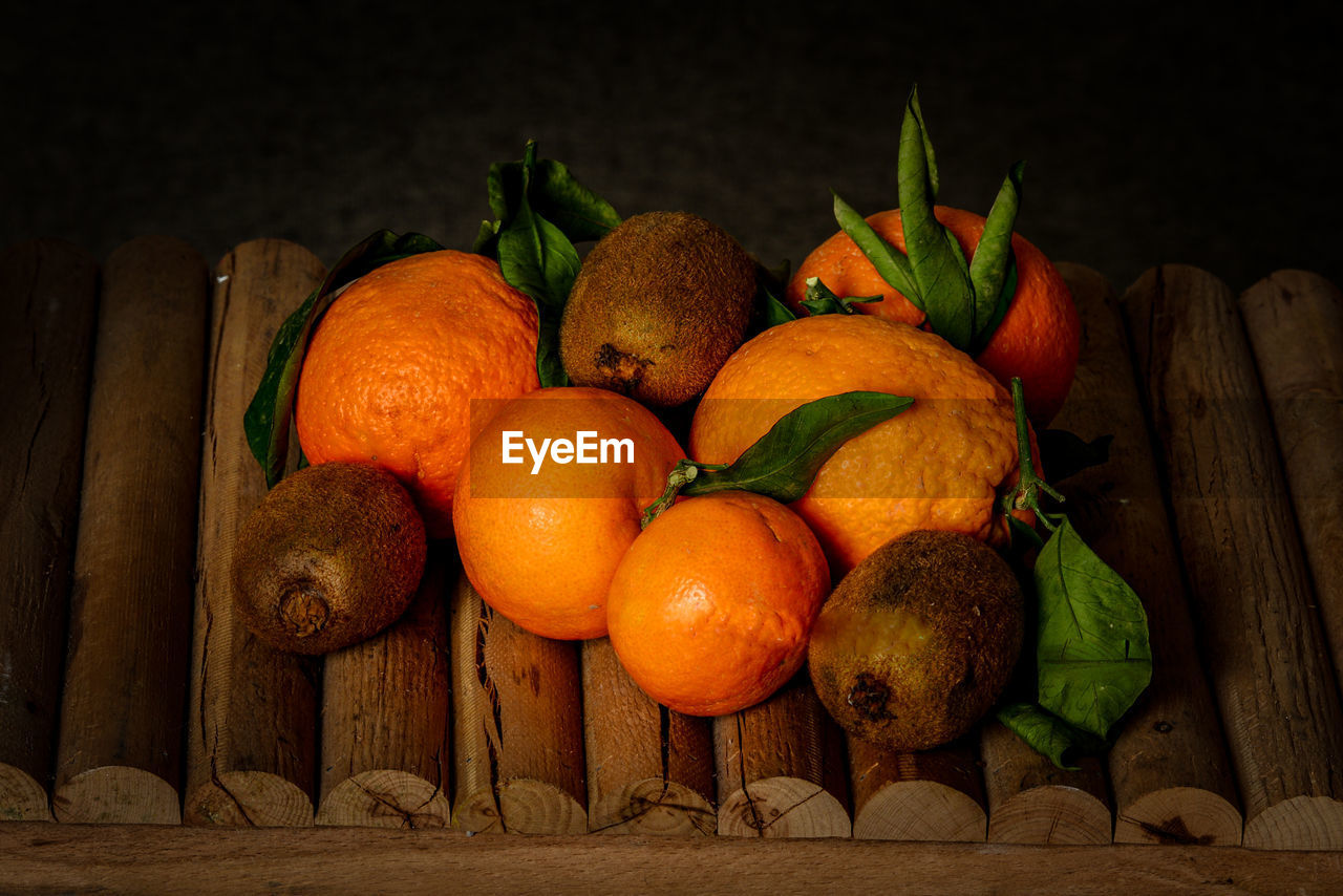 CLOSE-UP OF ORANGES ON WOOD