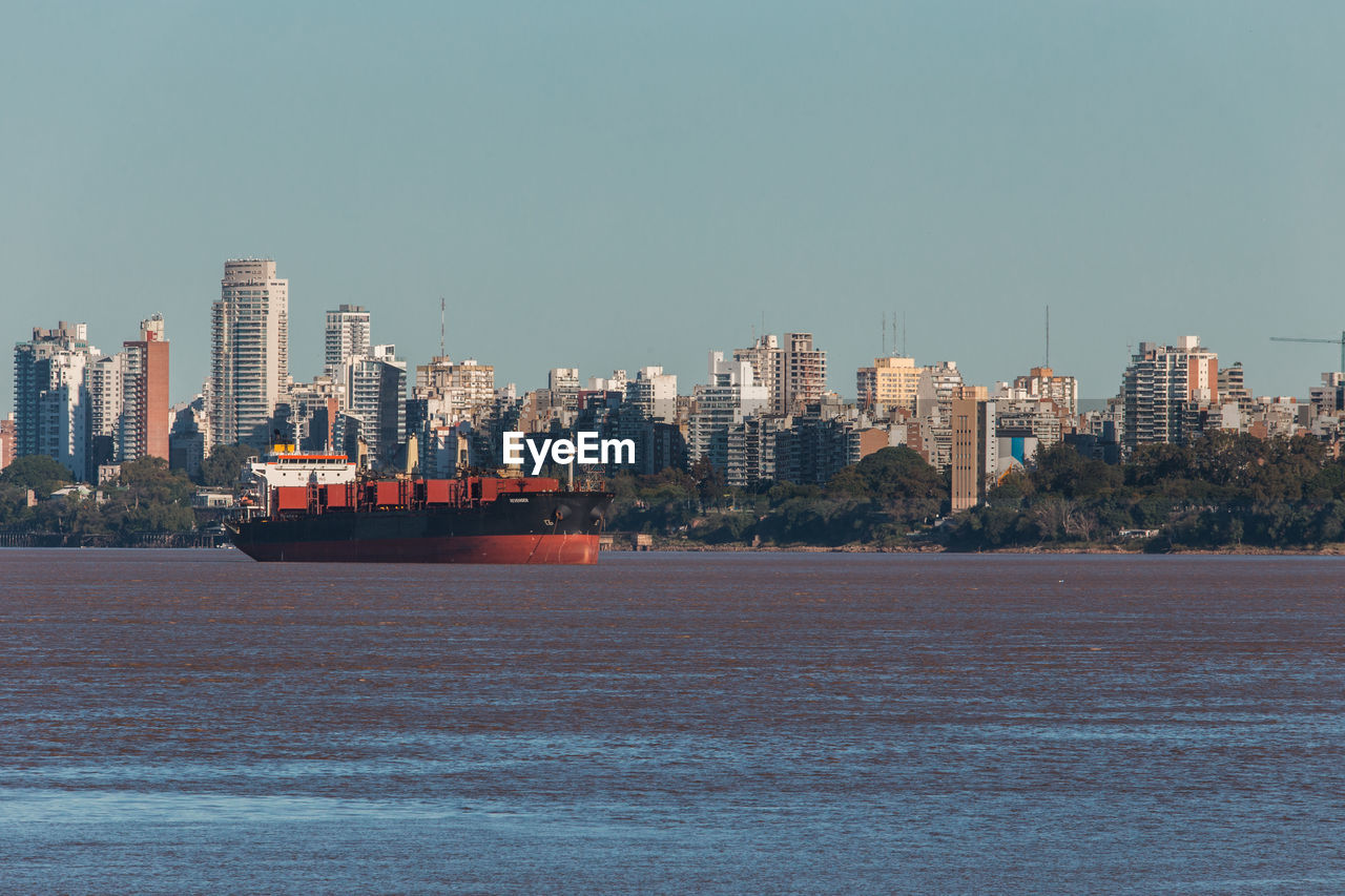 City by sea against clear sky