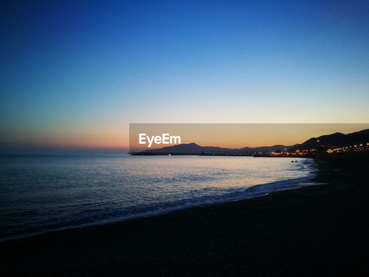 Scenic view of sea against clear sky at sunset