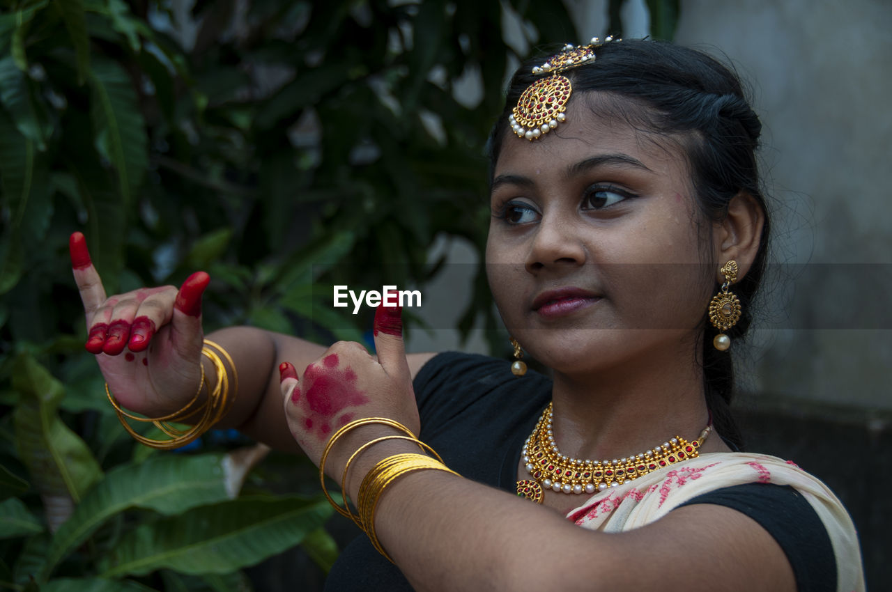 A teenage girl practicing bharatnatyam in nature