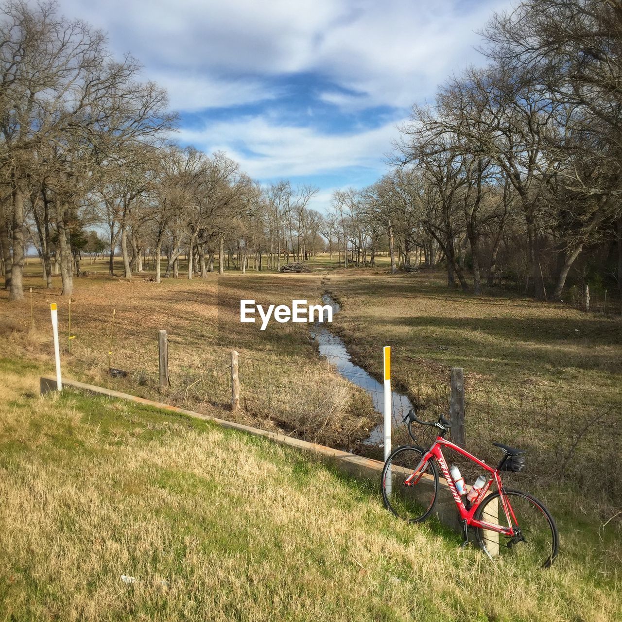 High angle view of bicycle parked on grassy field against cloudy sky