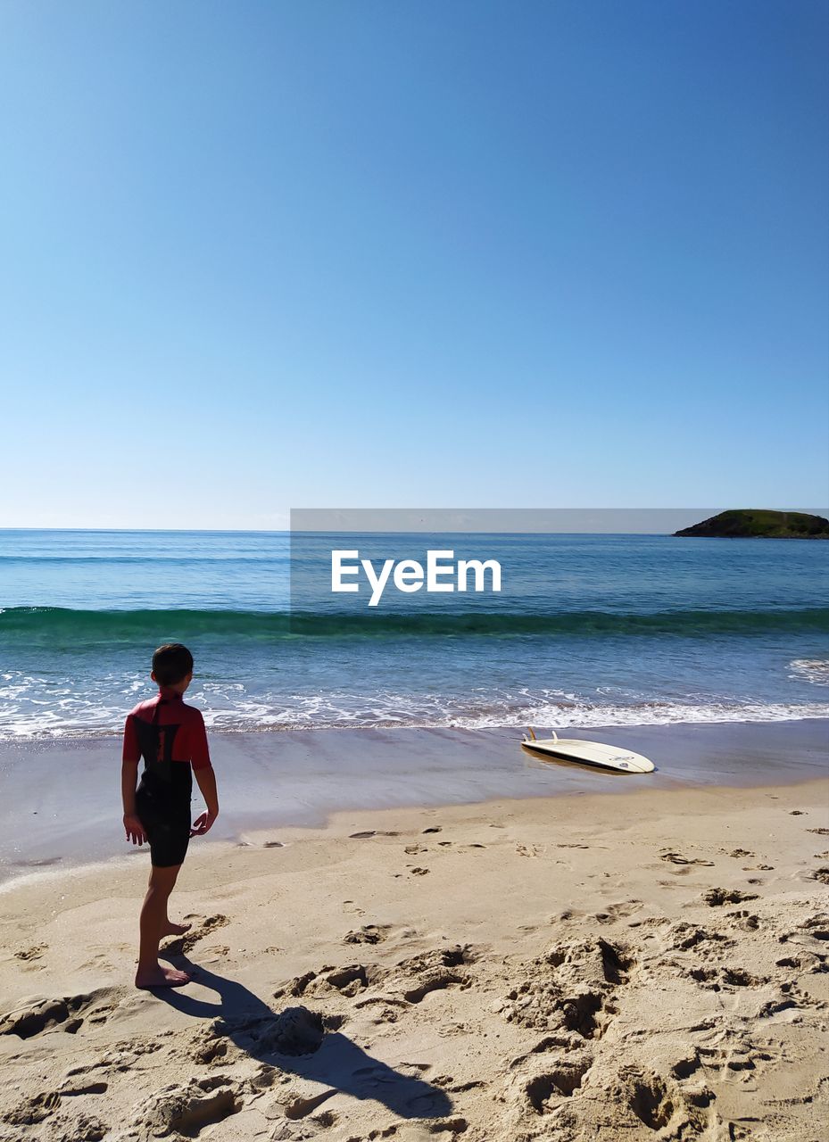 Full length of child on beach against clear sky