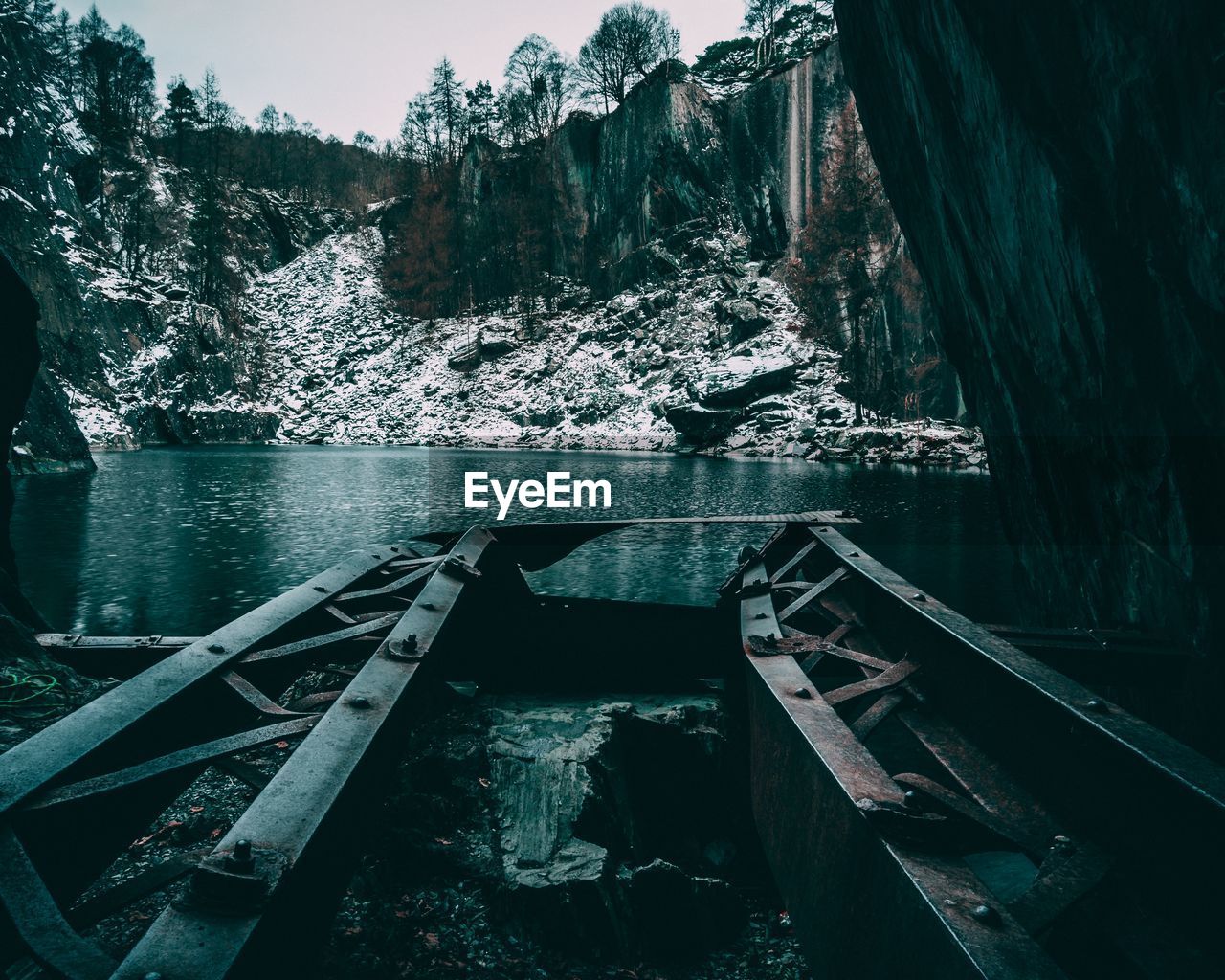 Abandoned boat on lake against rocky mountains