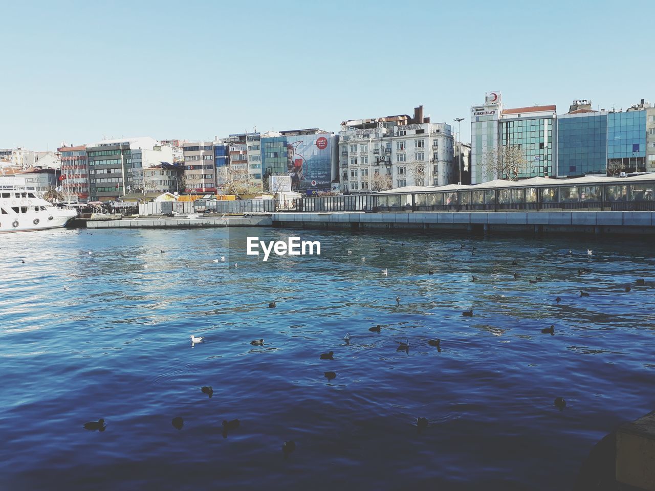 RIVER BY BUILDINGS AGAINST CLEAR SKY