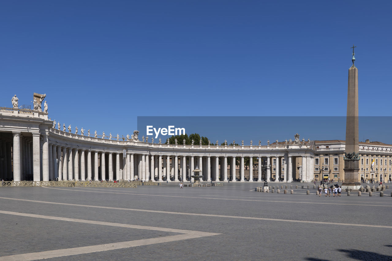Colonnades and obelisk at st. peter's square against clear blue sky, vatican city, italy