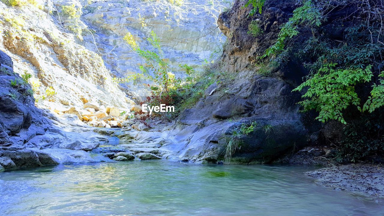 SCENIC VIEW OF STREAM FLOWING THROUGH ROCKS