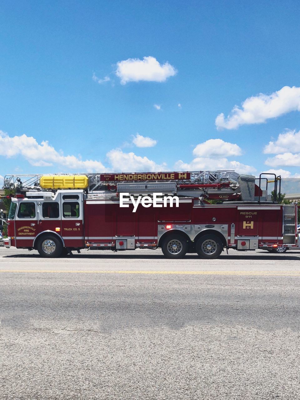 Fire engine on street in city against sky