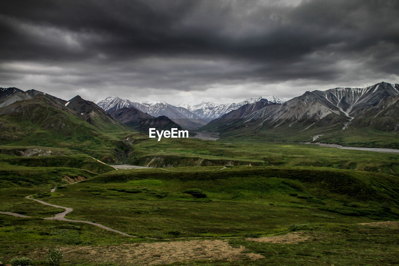 SCENIC VIEW OF MOUNTAINS AGAINST CLOUDY SKY