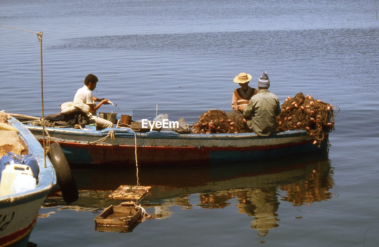 PEOPLE SITTING ON BOAT AT SEA