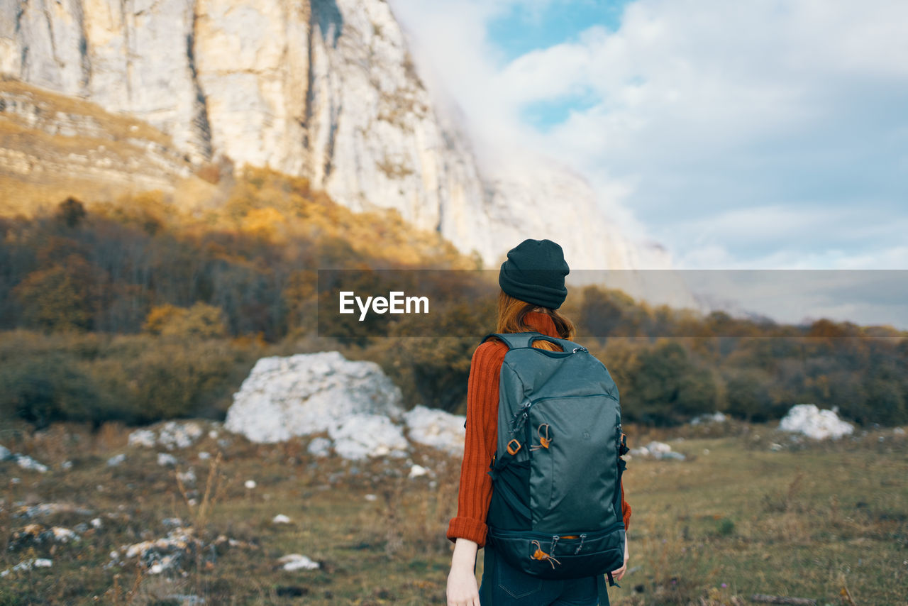 REAR VIEW OF MAN LOOKING AT MOUNTAIN