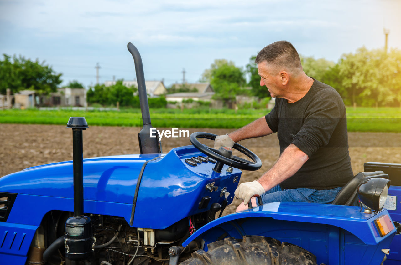 A farmer is driving a tractor. agro industry, agribusiness. farming, agriculture. 