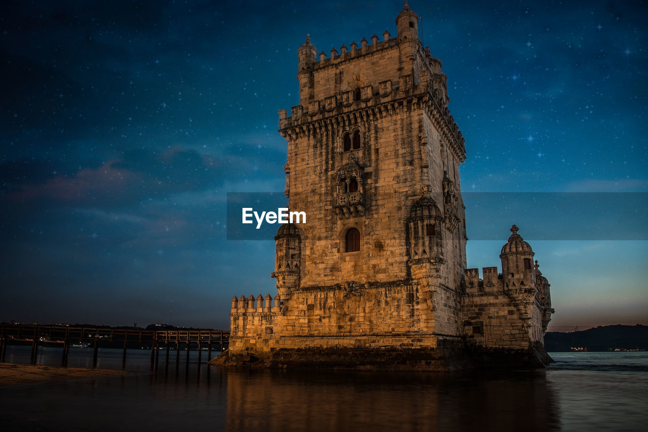 Torre de belem by river at night