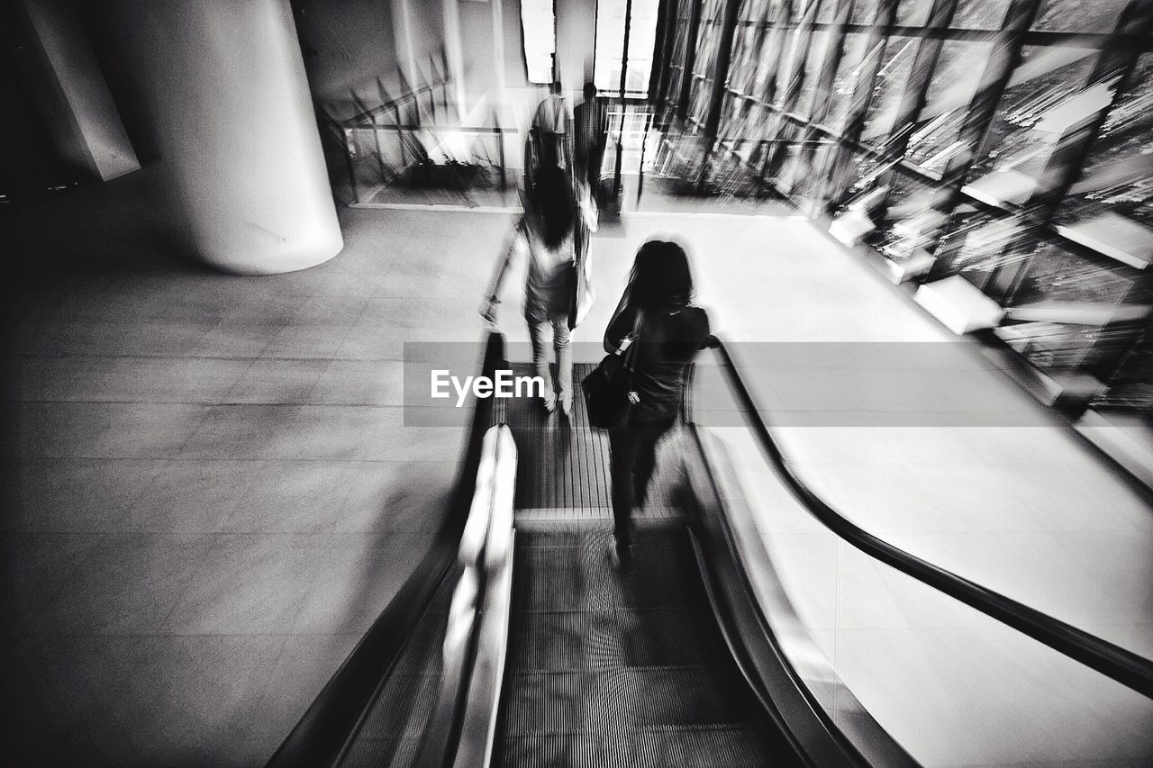 WOMAN STANDING ON ESCALATOR