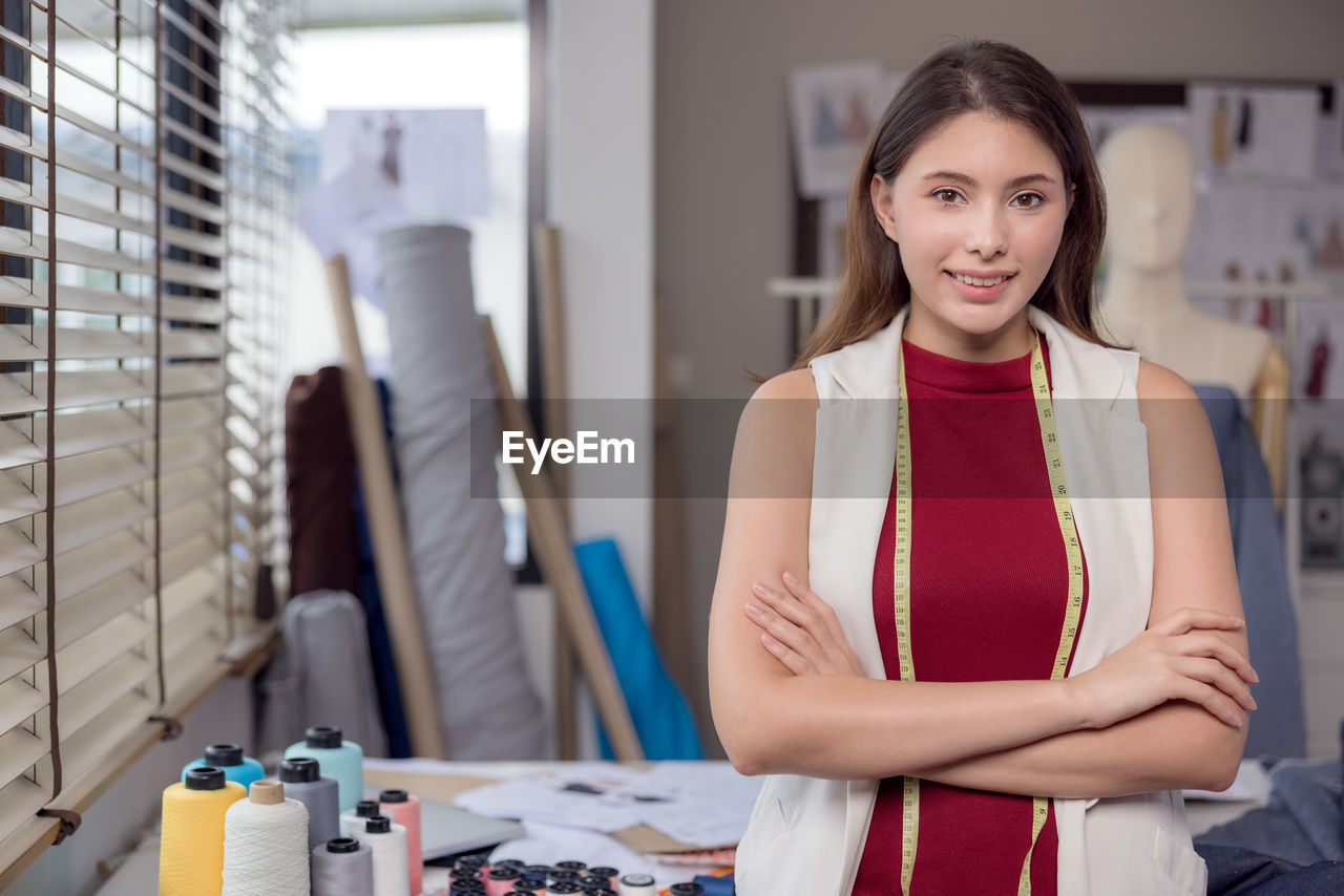 At work, a portrait of a smiling fashion designer and a creative woman is taken.